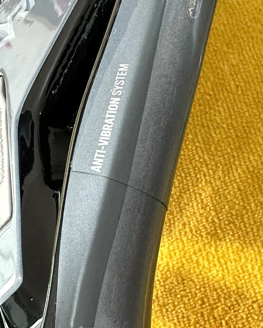 Close da garganta da raquete com a película aplicada, mostrando a borda fina e o acabamento transparente